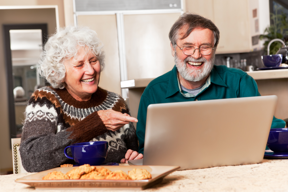 Zadowolona starsza para przy komputerze